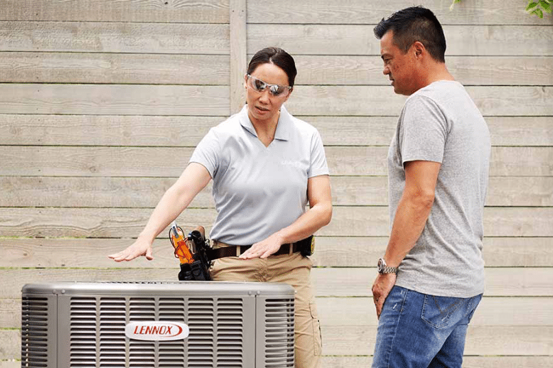 HVAC technician discussing AC repair with homeowner