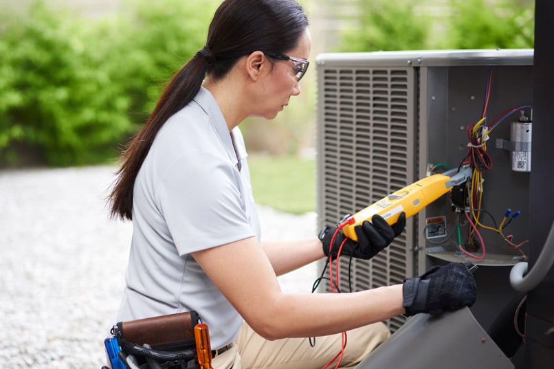 Woman working on an air conditioner